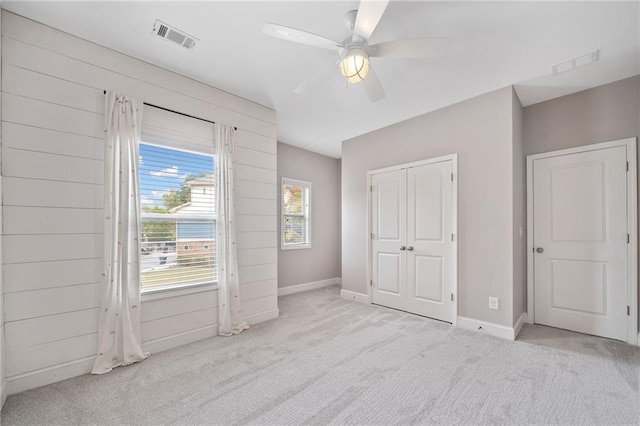 unfurnished bedroom featuring baseboards, a closet, visible vents, and carpet flooring