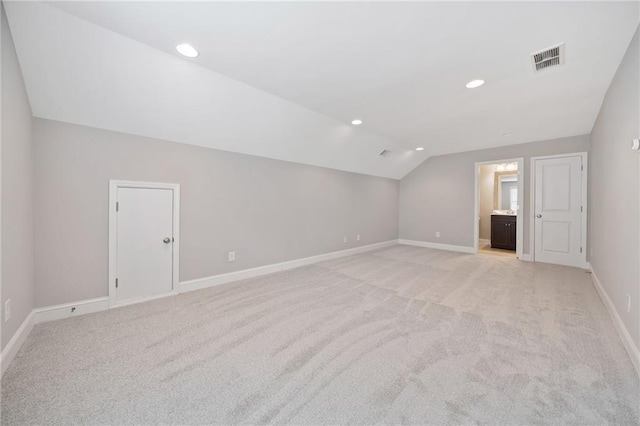 additional living space featuring recessed lighting, light colored carpet, visible vents, vaulted ceiling, and baseboards