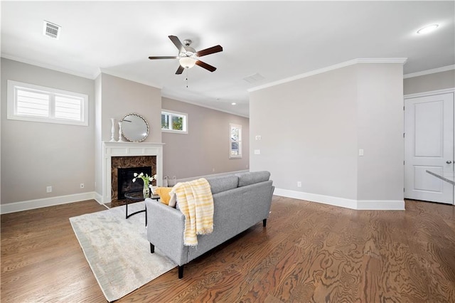 living area with baseboards, visible vents, and ornamental molding