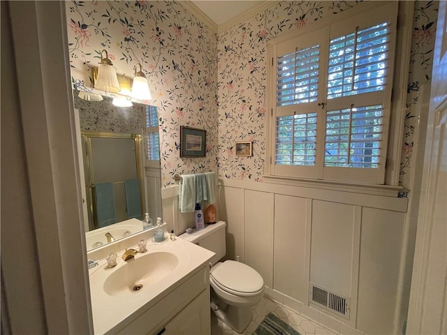 bathroom featuring vanity, toilet, and a shower with shower door