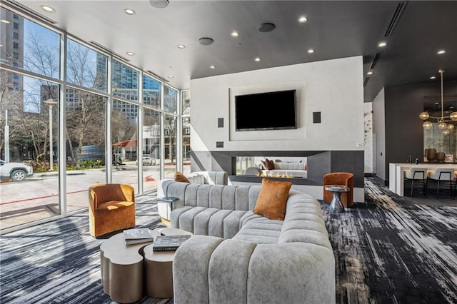 living area featuring recessed lighting, a healthy amount of sunlight, floor to ceiling windows, and visible vents