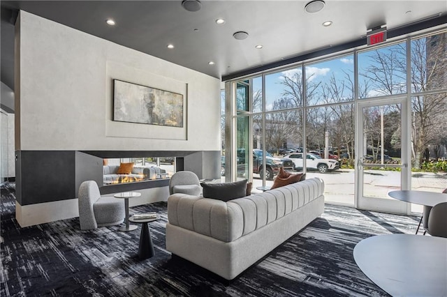 living area featuring a wall of windows, a multi sided fireplace, and a wealth of natural light