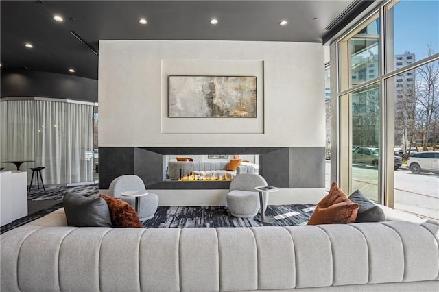 living room featuring floor to ceiling windows, a multi sided fireplace, and recessed lighting