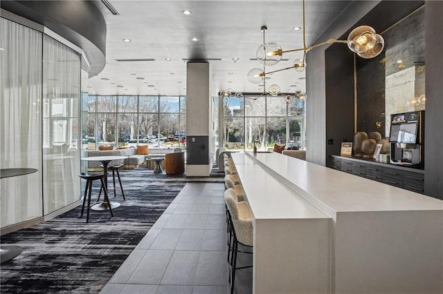 interior space featuring recessed lighting, dark tile patterned flooring, a high ceiling, a kitchen island, and open floor plan