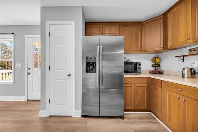 276 Arbor Gate Dr, Cornelia, GA 30531 - kitchen with stainless steel refrigerator with ice dispenser, brown cabinets, light countertops, and light wood-style flooring