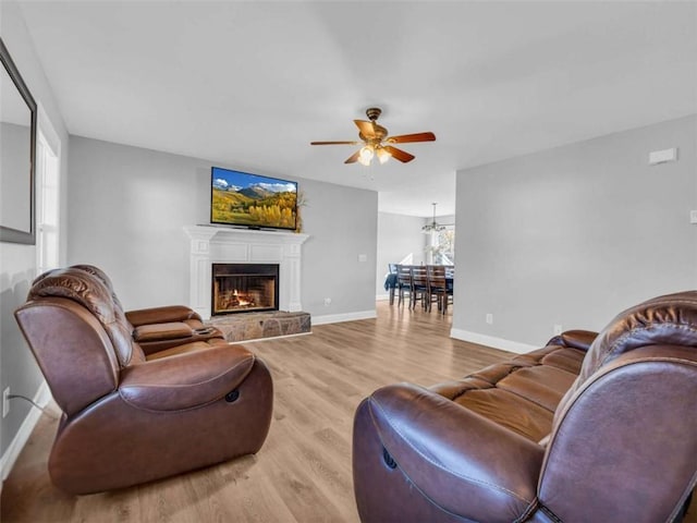 276 Arbor Gate Dr, Cornelia, GA 30531 - living area with wood finished floors, a ceiling fan, and a lit fireplace