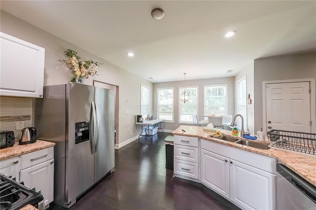 kitchen featuring baseboards, a sink, white cabinetry, and appliances with stainless steel finishes