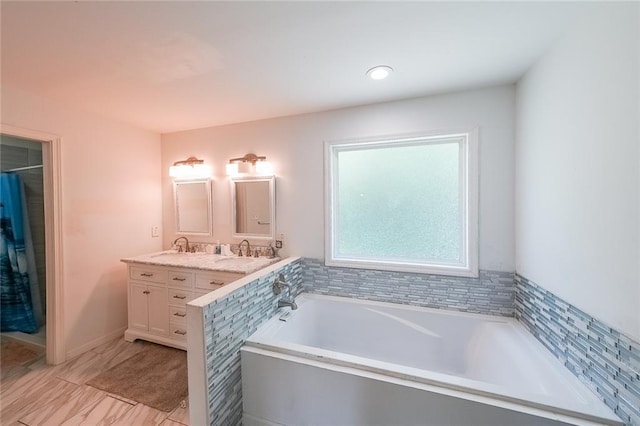bathroom featuring double vanity, a sink, and a garden tub