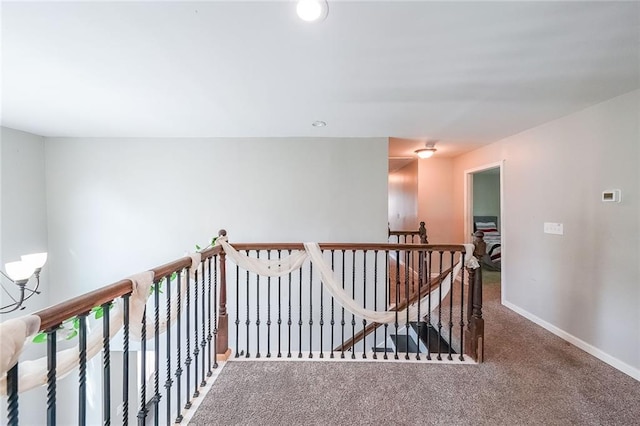 corridor featuring carpet flooring, recessed lighting, baseboards, and an upstairs landing