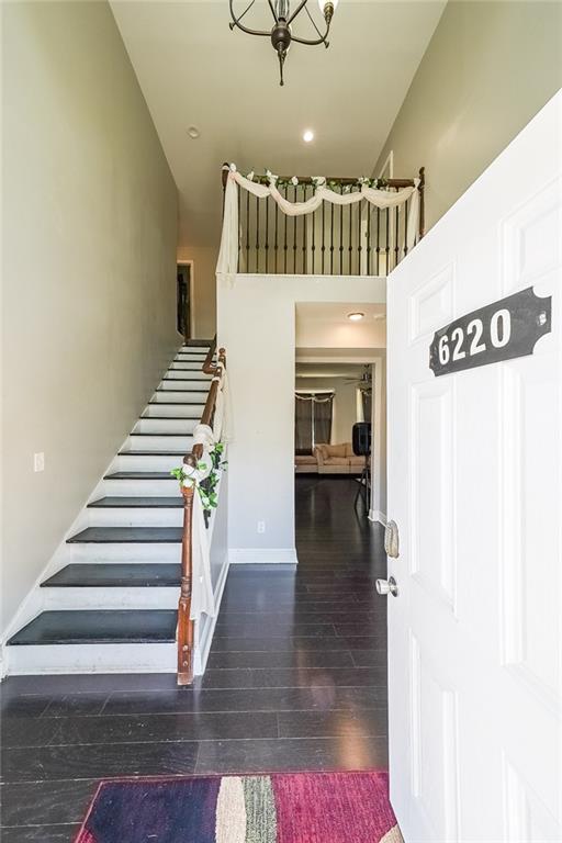 entryway with stairway, baseboards, a high ceiling, and hardwood / wood-style flooring