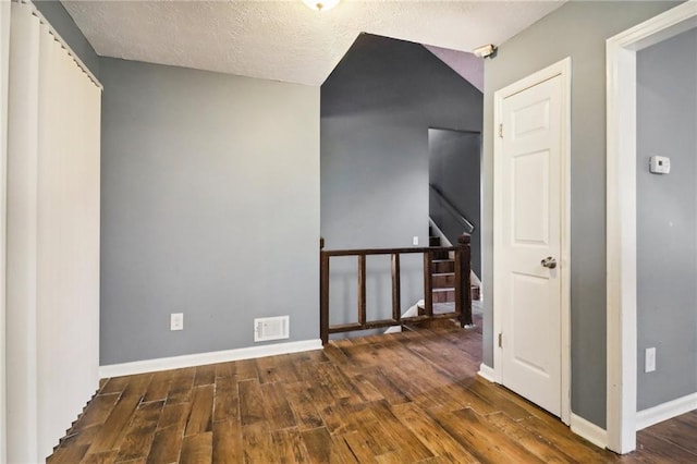 interior space with a textured ceiling and dark hardwood / wood-style flooring