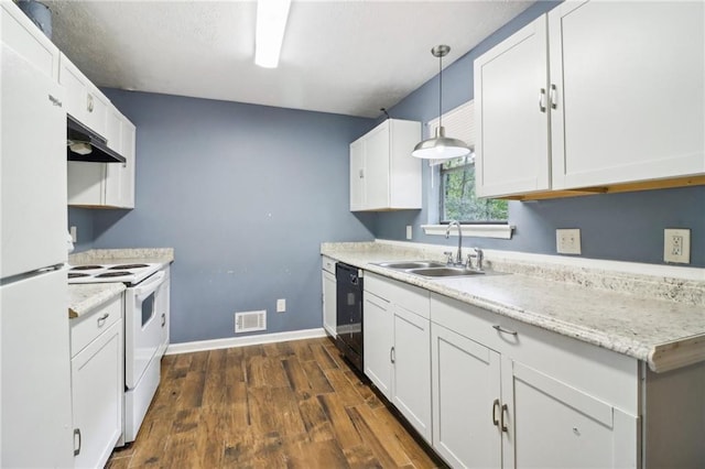 kitchen with white appliances, hanging light fixtures, and white cabinets