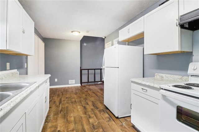 kitchen featuring dark hardwood / wood-style floors, white cabinets, and white appliances