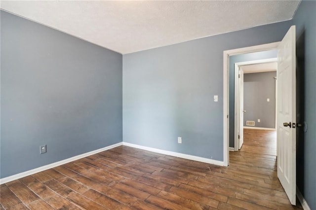 empty room with dark wood-type flooring