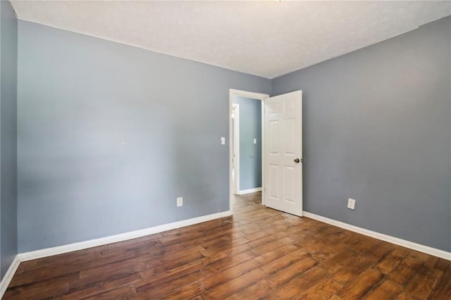 unfurnished room with wood-type flooring