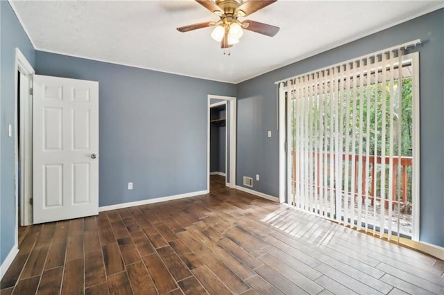 unfurnished bedroom featuring dark wood-type flooring, ceiling fan, a spacious closet, access to outside, and a closet