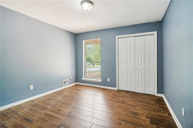 unfurnished bedroom featuring dark wood-type flooring and a closet