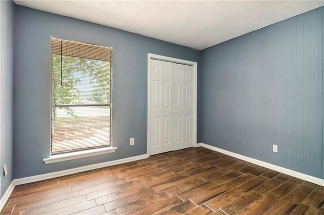 unfurnished bedroom featuring dark wood-type flooring and a closet