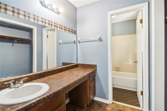 bathroom featuring hardwood / wood-style flooring, shower / bathtub combination, and vanity