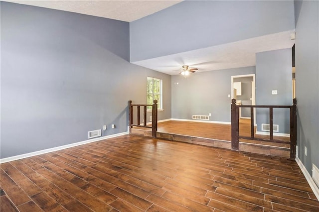 empty room with dark hardwood / wood-style flooring and ceiling fan