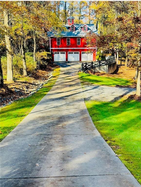 exterior space featuring a garage, driveway, and a lawn