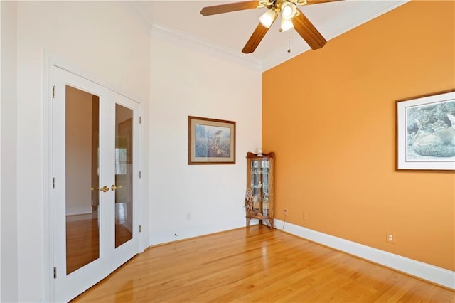 empty room featuring crown molding, french doors, ceiling fan, and light wood-type flooring