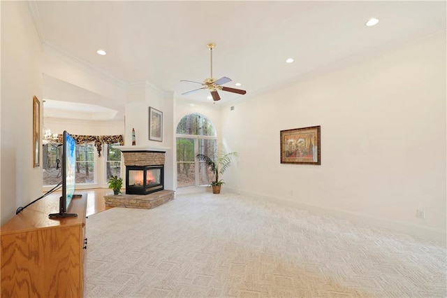 unfurnished living room with a fireplace, a wealth of natural light, light colored carpet, and ceiling fan