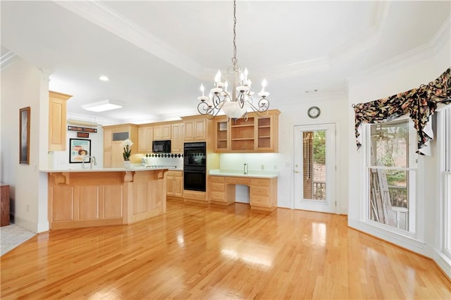 kitchen featuring light brown cabinets, light wood-type flooring, a chandelier, and black appliances