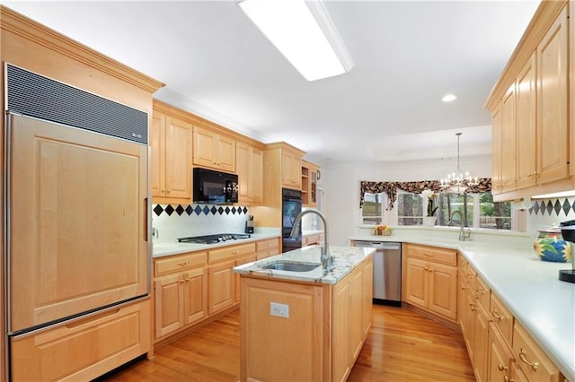 kitchen with black appliances, a kitchen island with sink, an inviting chandelier, light brown cabinets, and light wood-type flooring