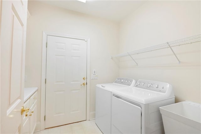 clothes washing area featuring light tile floors, washing machine and dryer, and sink