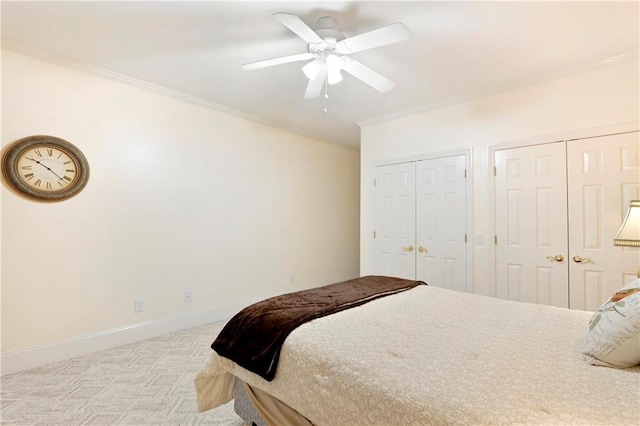 bedroom with multiple closets, ceiling fan, crown molding, and light colored carpet