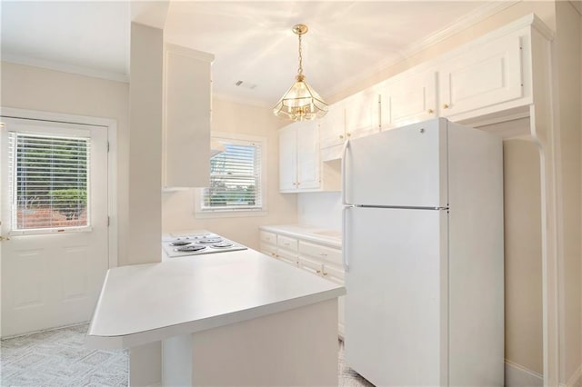 kitchen featuring white cabinetry, crown molding, white fridge, and pendant lighting