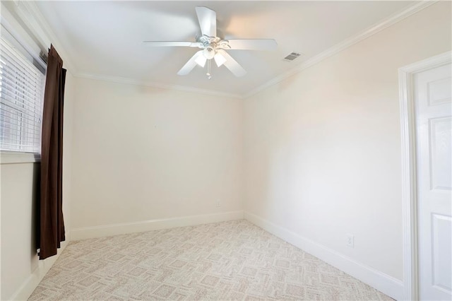 carpeted spare room with ceiling fan and ornamental molding