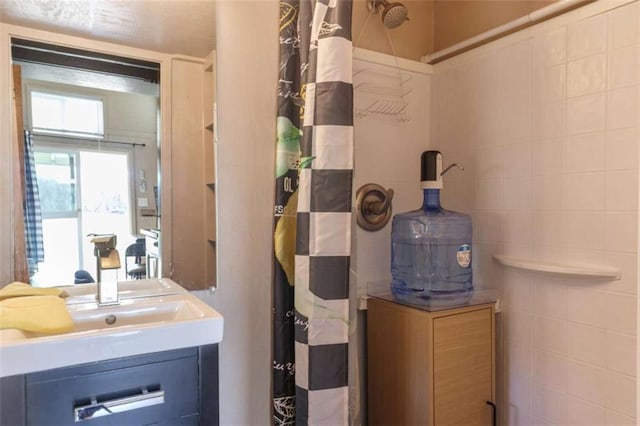 full bathroom featuring a sink and tile walls