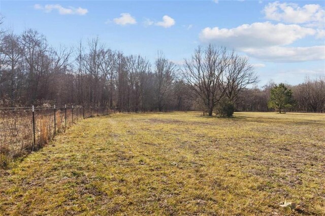 view of yard featuring a rural view and fence