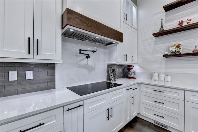 kitchen featuring white cabinetry, black electric stovetop, and custom exhaust hood