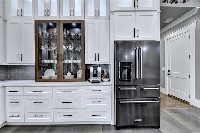 bar with high end refrigerator and white cabinetry