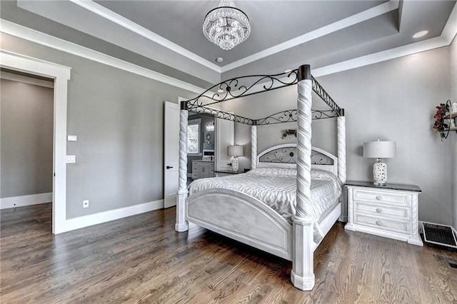 bedroom with dark wood-type flooring, crown molding, a notable chandelier, and a raised ceiling