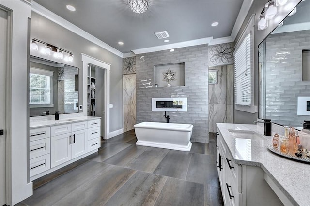 bathroom featuring crown molding, vanity, and a bathtub