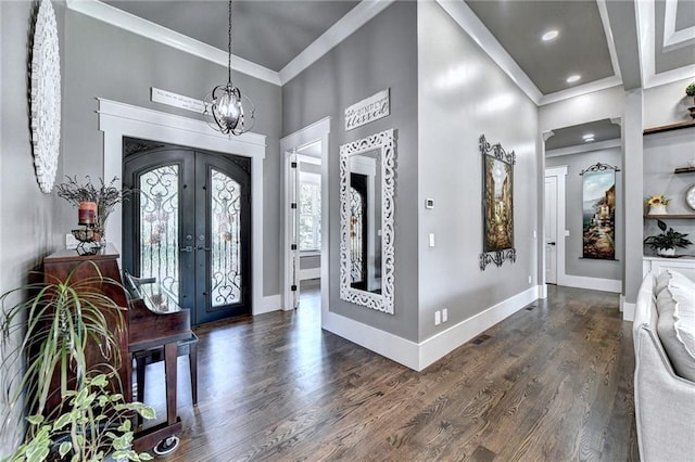 entrance foyer featuring french doors, a notable chandelier, a high ceiling, crown molding, and dark hardwood / wood-style floors