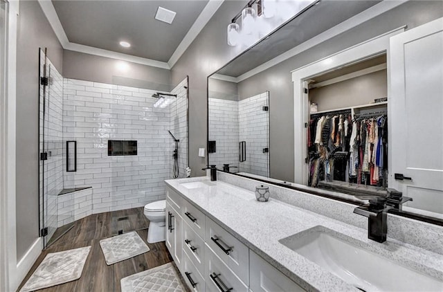 bathroom with hardwood / wood-style flooring, vanity, and a shower with door