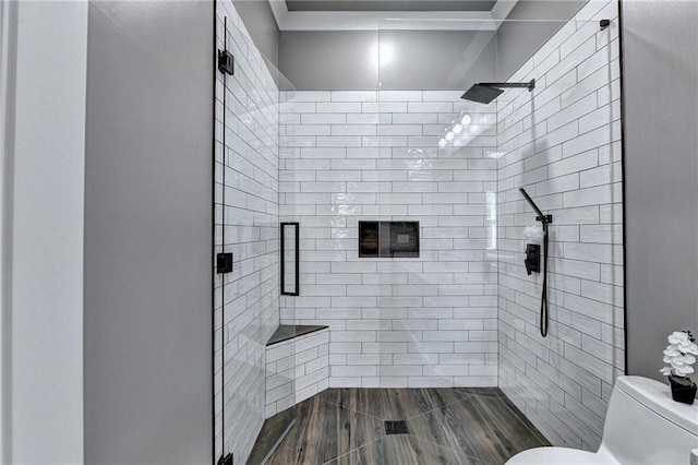 bathroom featuring toilet and a shower with door