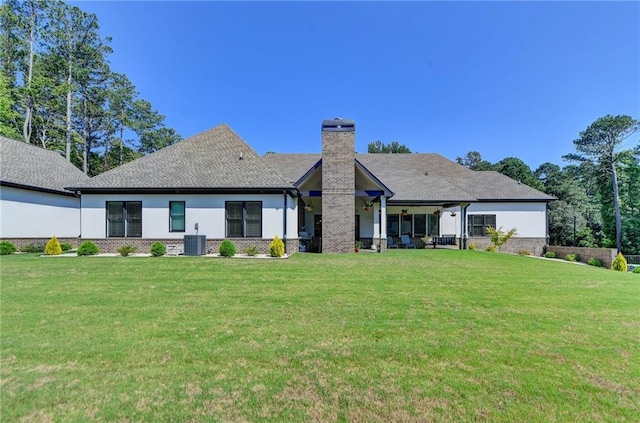 back of house featuring central AC unit and a lawn