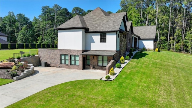 rear view of house with a lawn and central AC