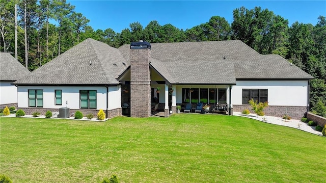 back of property with a patio area, central AC unit, and a lawn