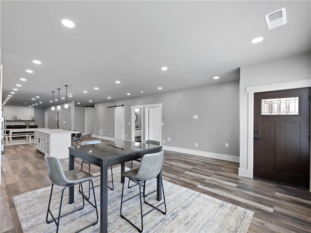 dining space featuring hardwood / wood-style floors and a barn door