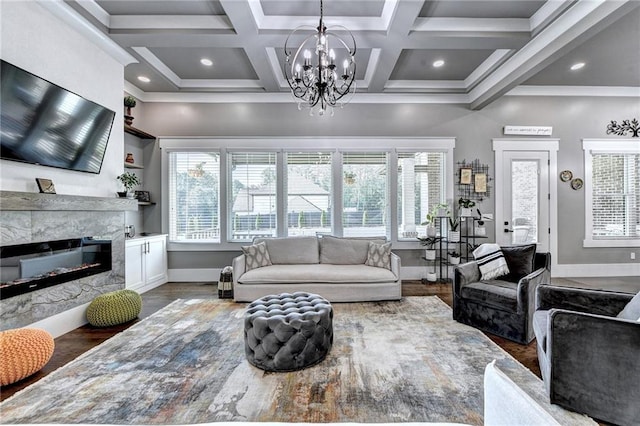 living room with a fireplace, beam ceiling, dark wood-type flooring, and an inviting chandelier