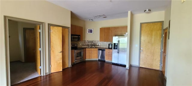 kitchen featuring dark countertops, tasteful backsplash, appliances with stainless steel finishes, and dark wood-type flooring