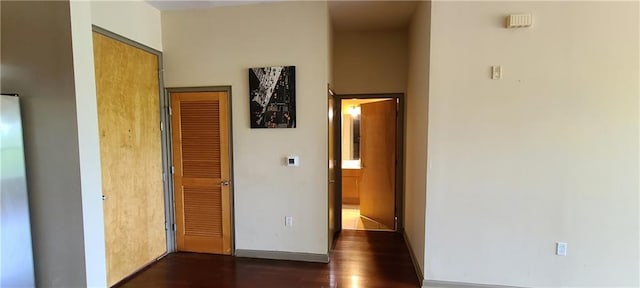 corridor with baseboards and dark wood finished floors