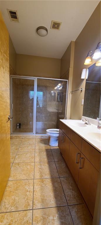 bathroom featuring toilet, tile patterned flooring, visible vents, and a shower stall